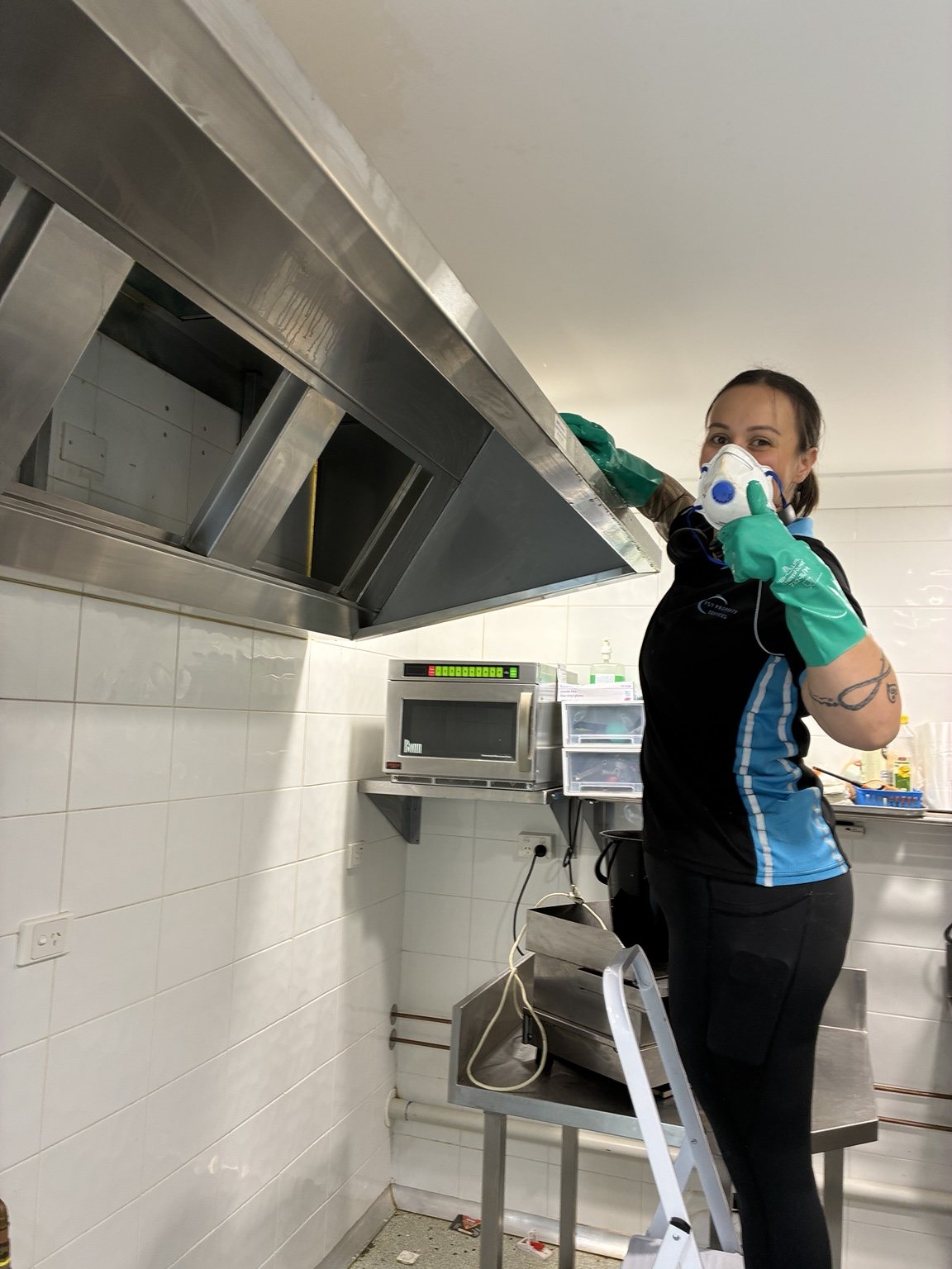FST team member cleaning a commercial kitchen rangehood
